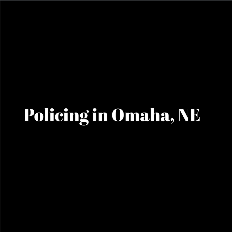 On a black background, simple white text reads Policing in Omaha, Nebraska